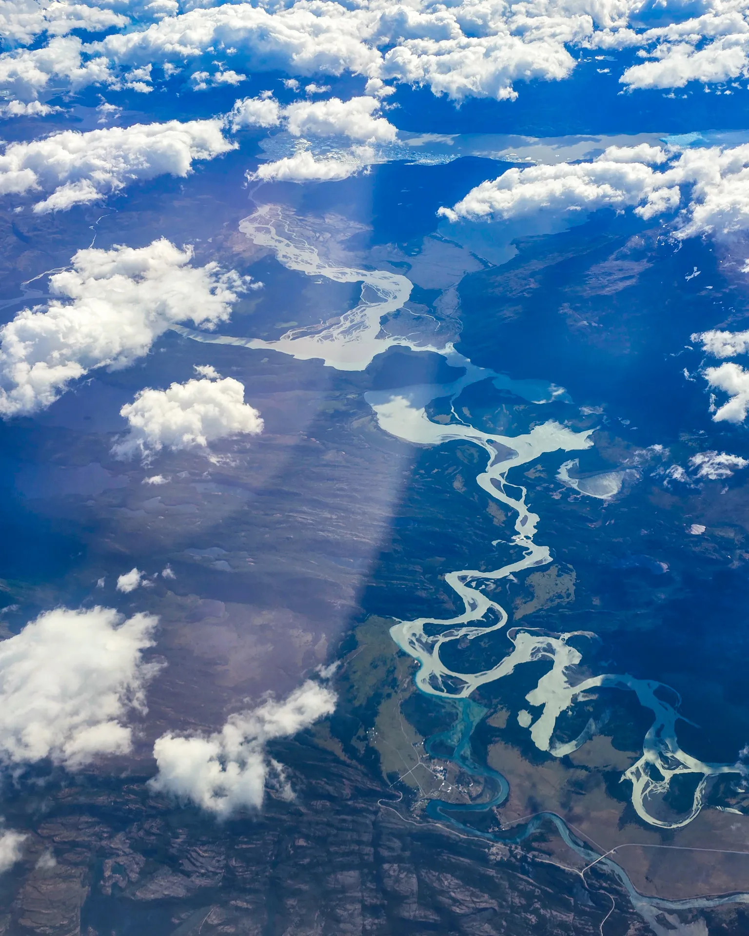 Andes Airplane Shot 2: showing winding river between mountains and clouds above