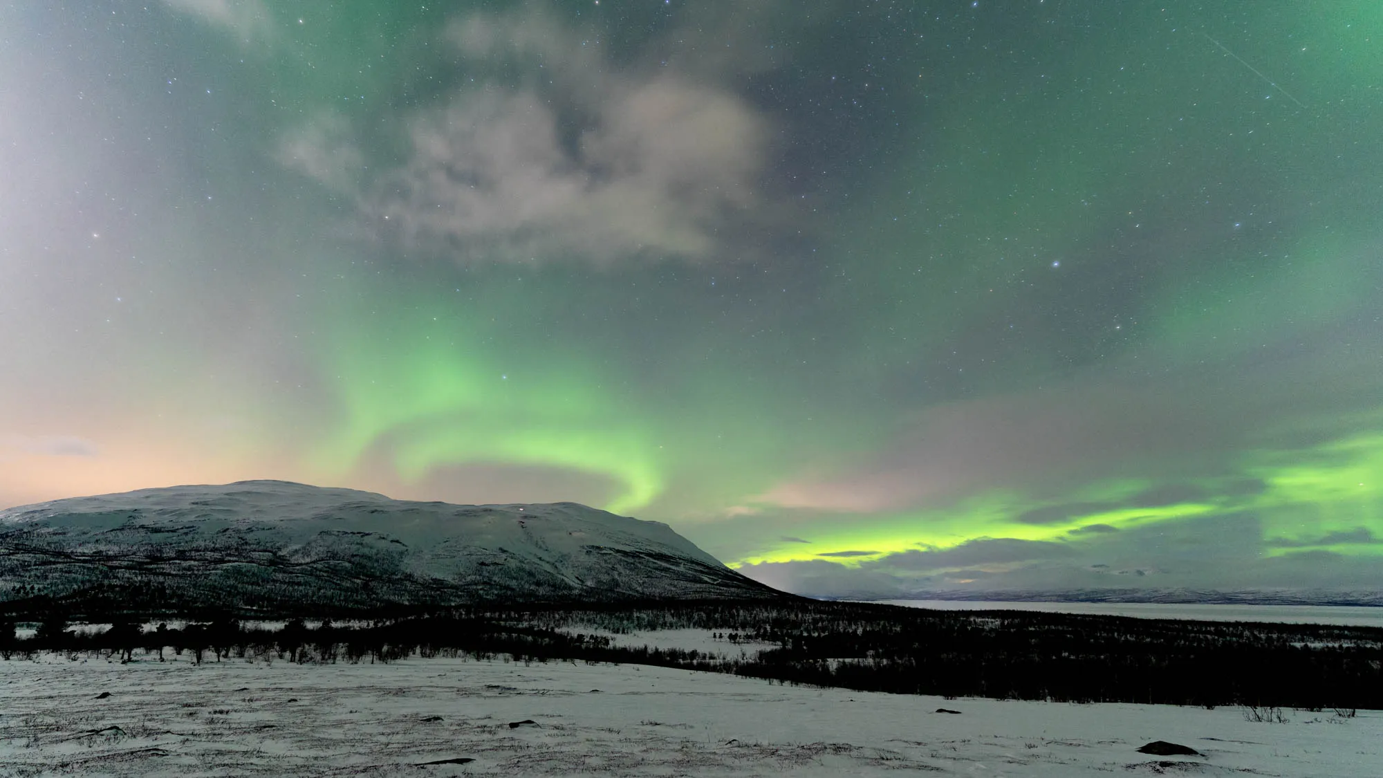 swirling aurora above mountain