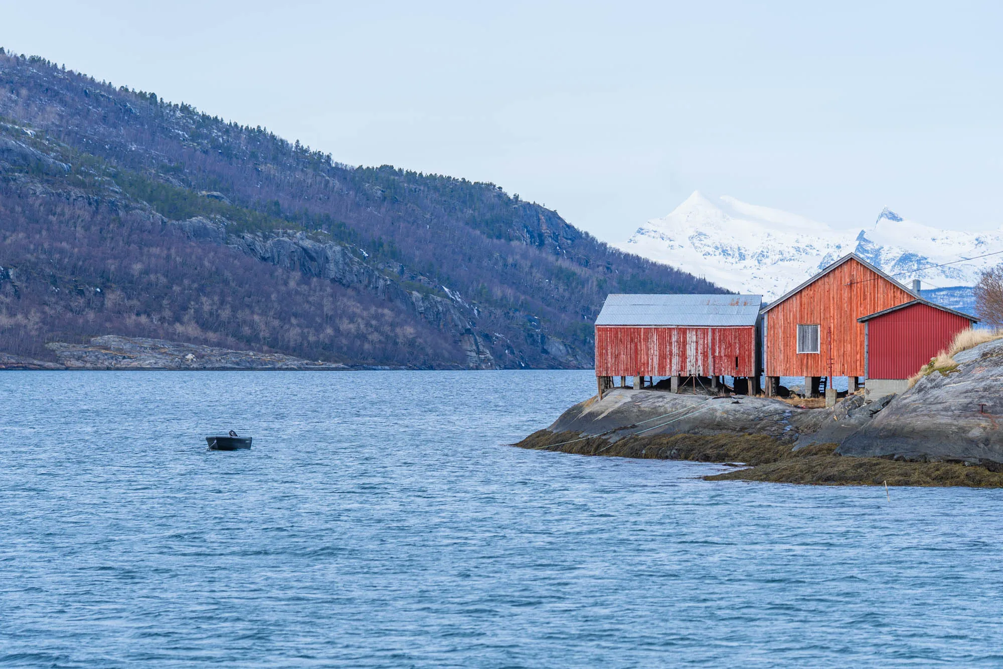 house on a fjord and small boat in the water