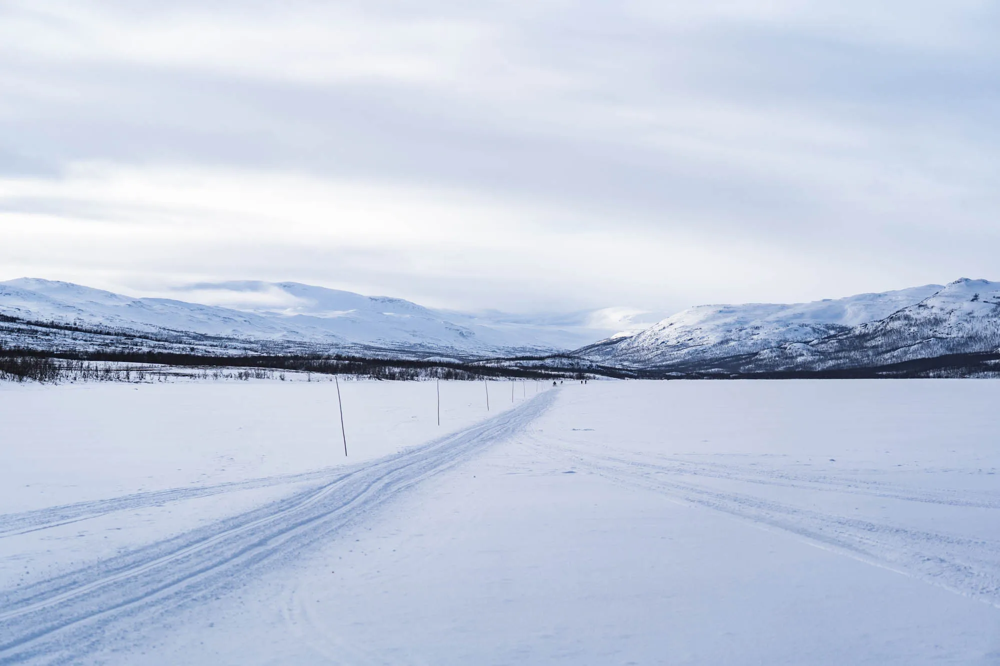 wide angle shot of giant frozen lake lined with mountains