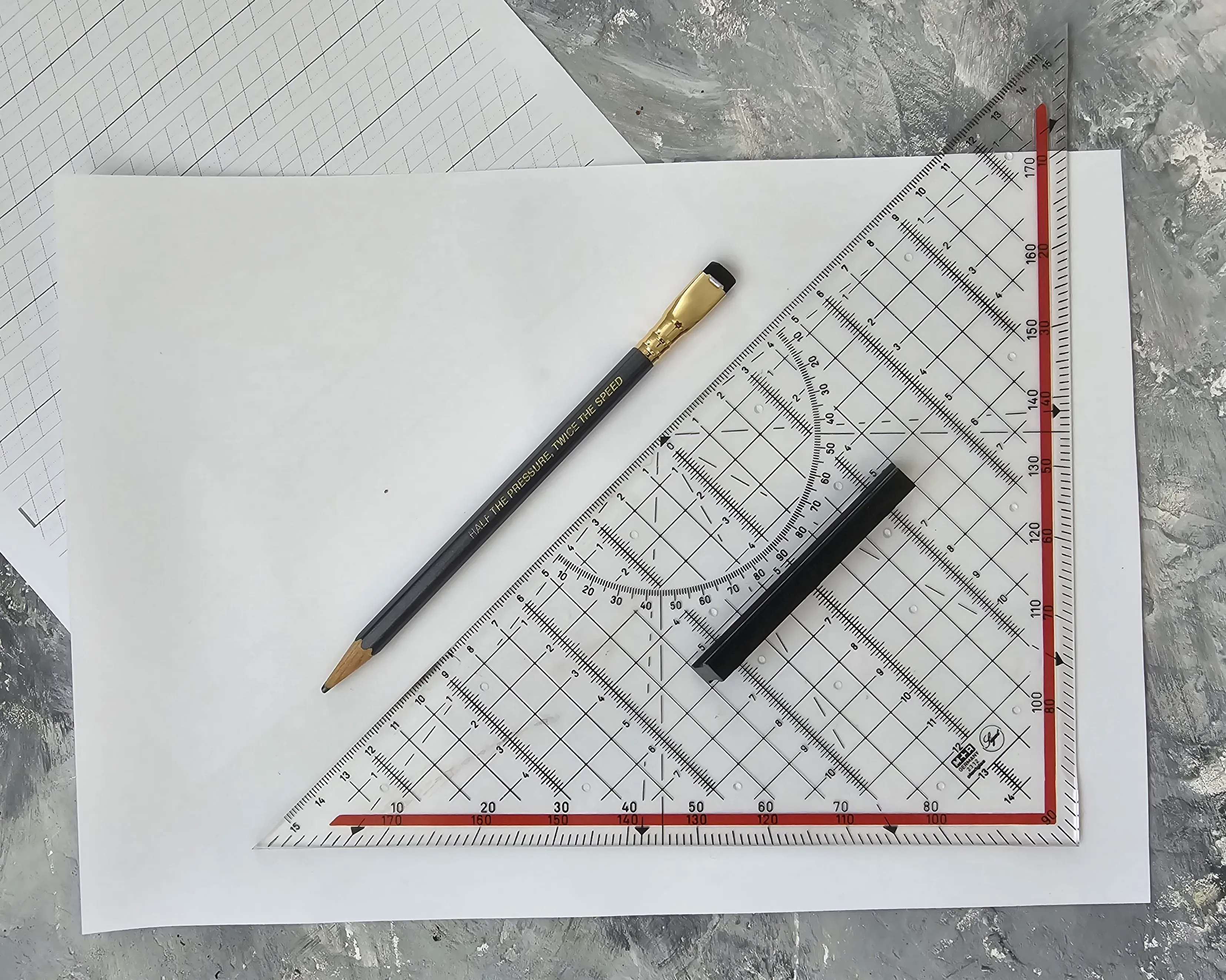 set square and pencil lying on a sheet of paper