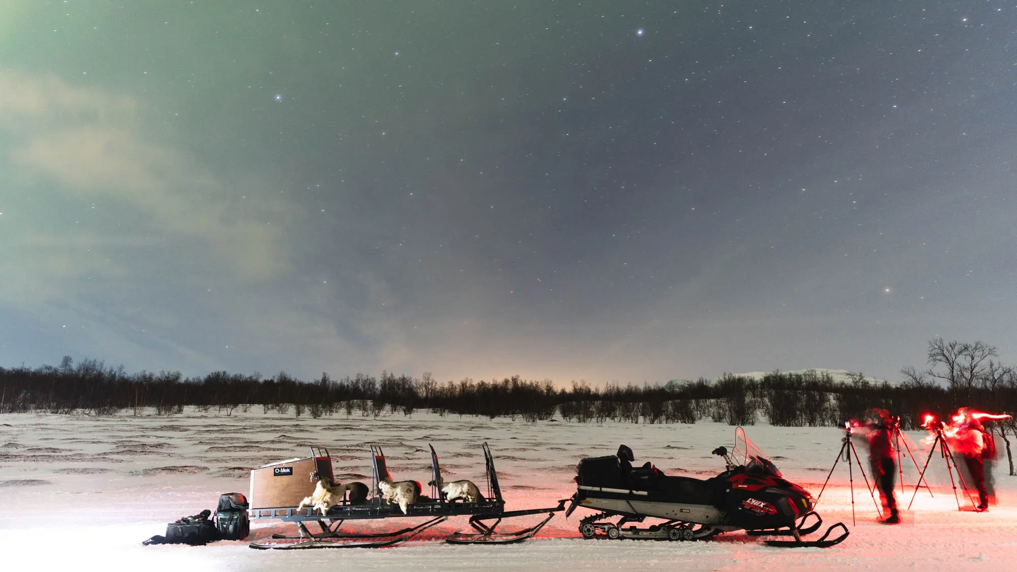 long exposure shot of snow mobile, streaks of photographers with head torches add light streaks to the photo